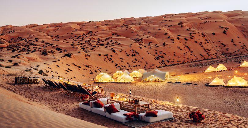 Sunset view of a luxury tented camp in Wahiba Sands, Oman