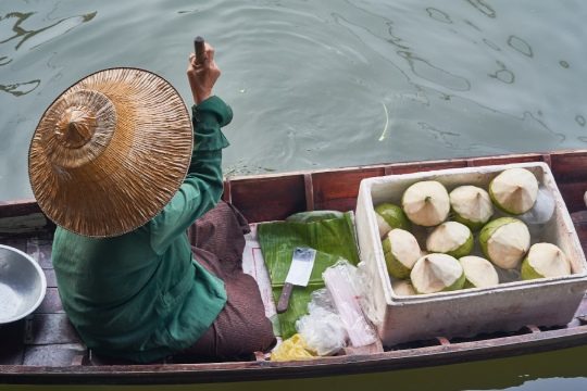 Floating market lady selling coconuts